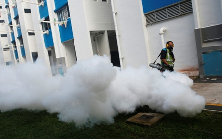 Nhân viên y tế Singapore phun thuốc phòng dịch Zika lây lan trong khu dân cư.